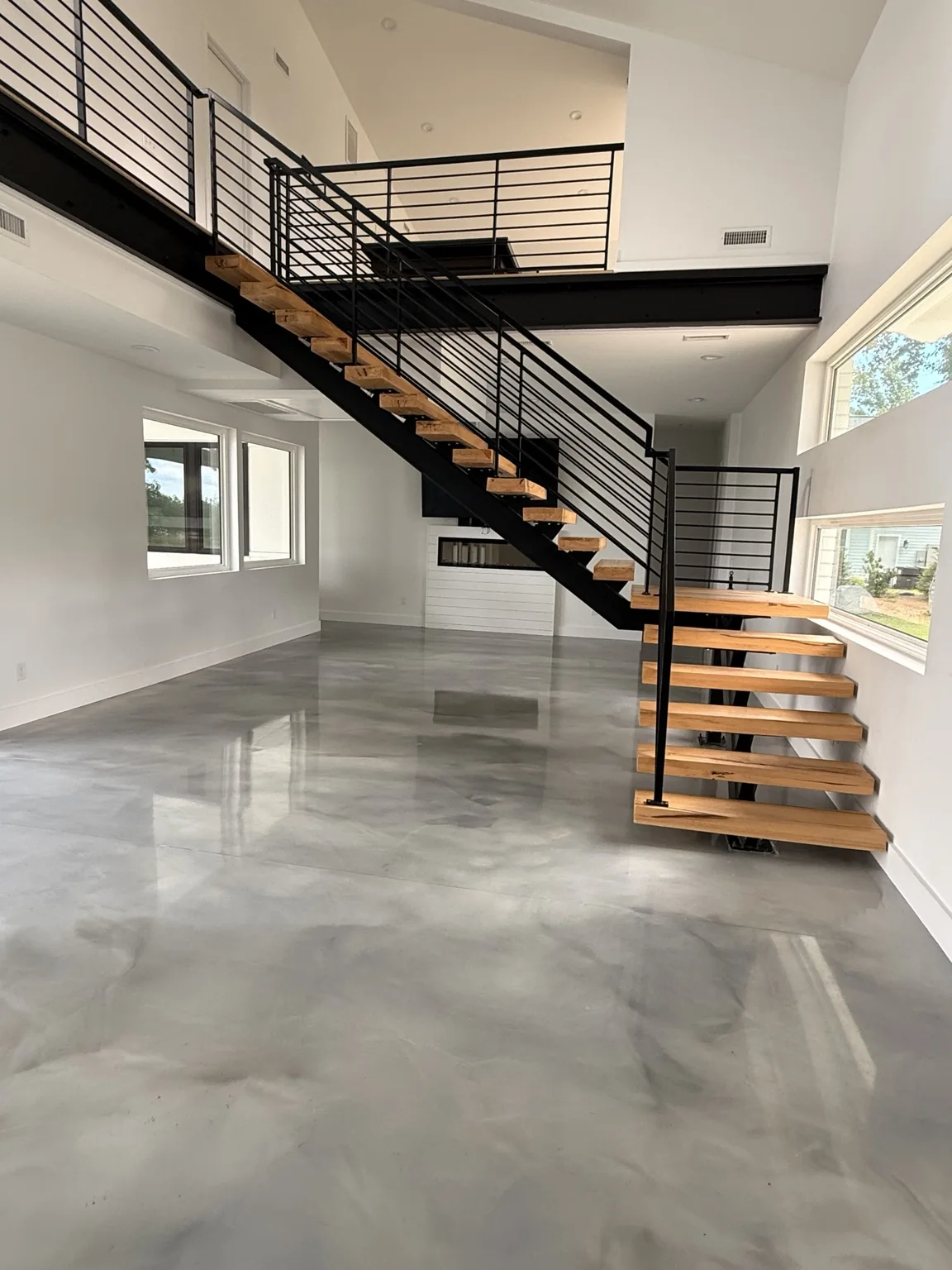 Bright open-plan home with modern wood staircase, cleaned by Brazilian Shine